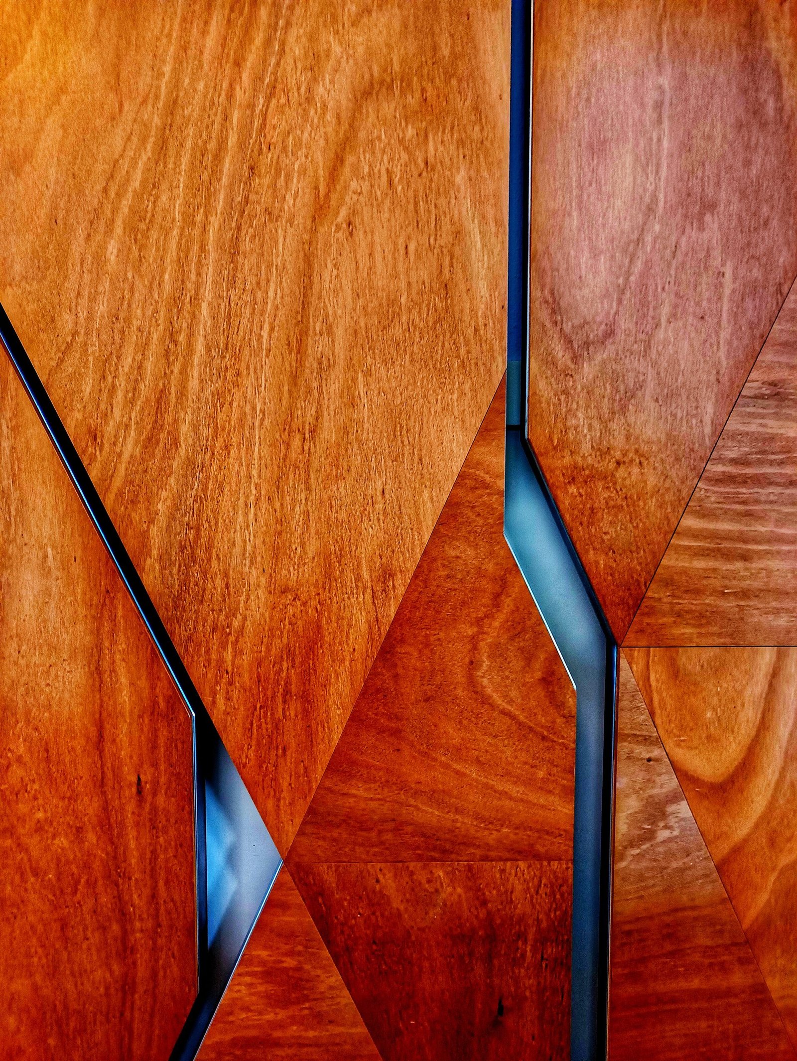 Abstract geometric design featuring natural wood textures and sleek metal accents.