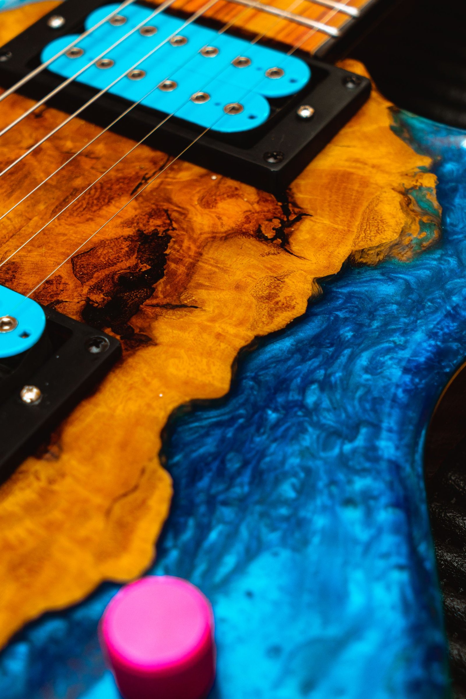 Detailed view of a vibrant electric guitar body with wood grain and vibrant colors.
